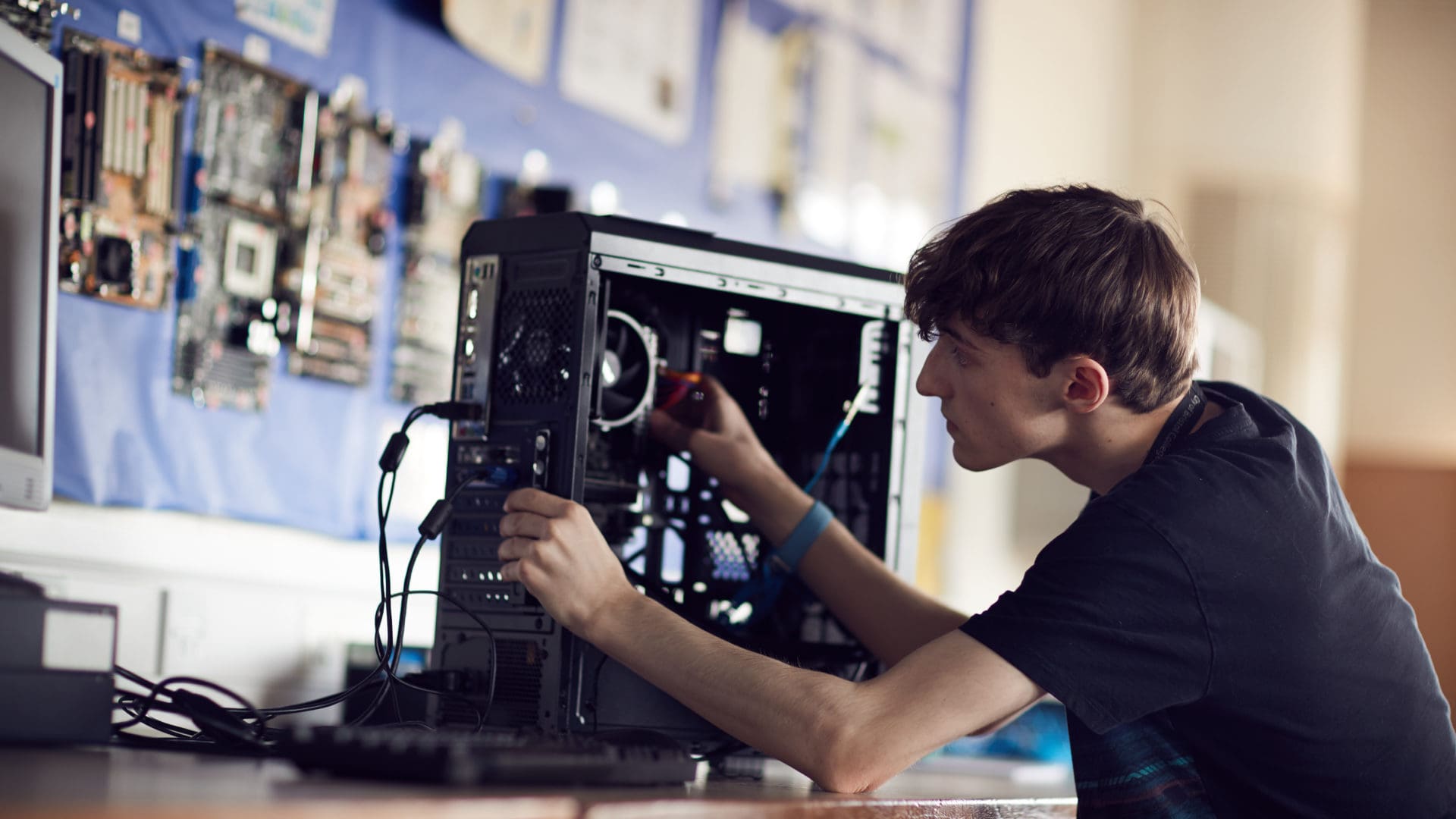 żapp student focusing on fixing a computer on an IT course